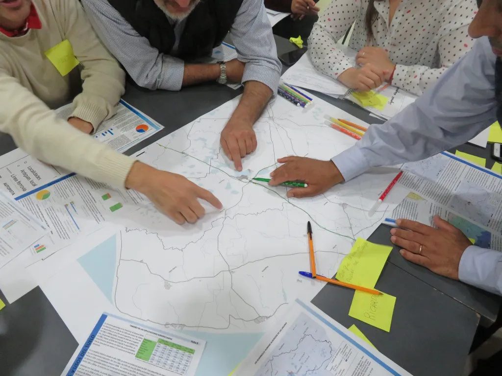Atelier de cartographie participative : des mains posées sur une carte avec des post-it